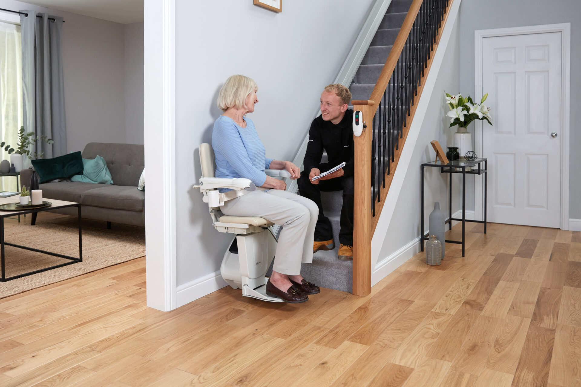 An elderly woman happily chats with an Engineer from the comfort of her stairlift.