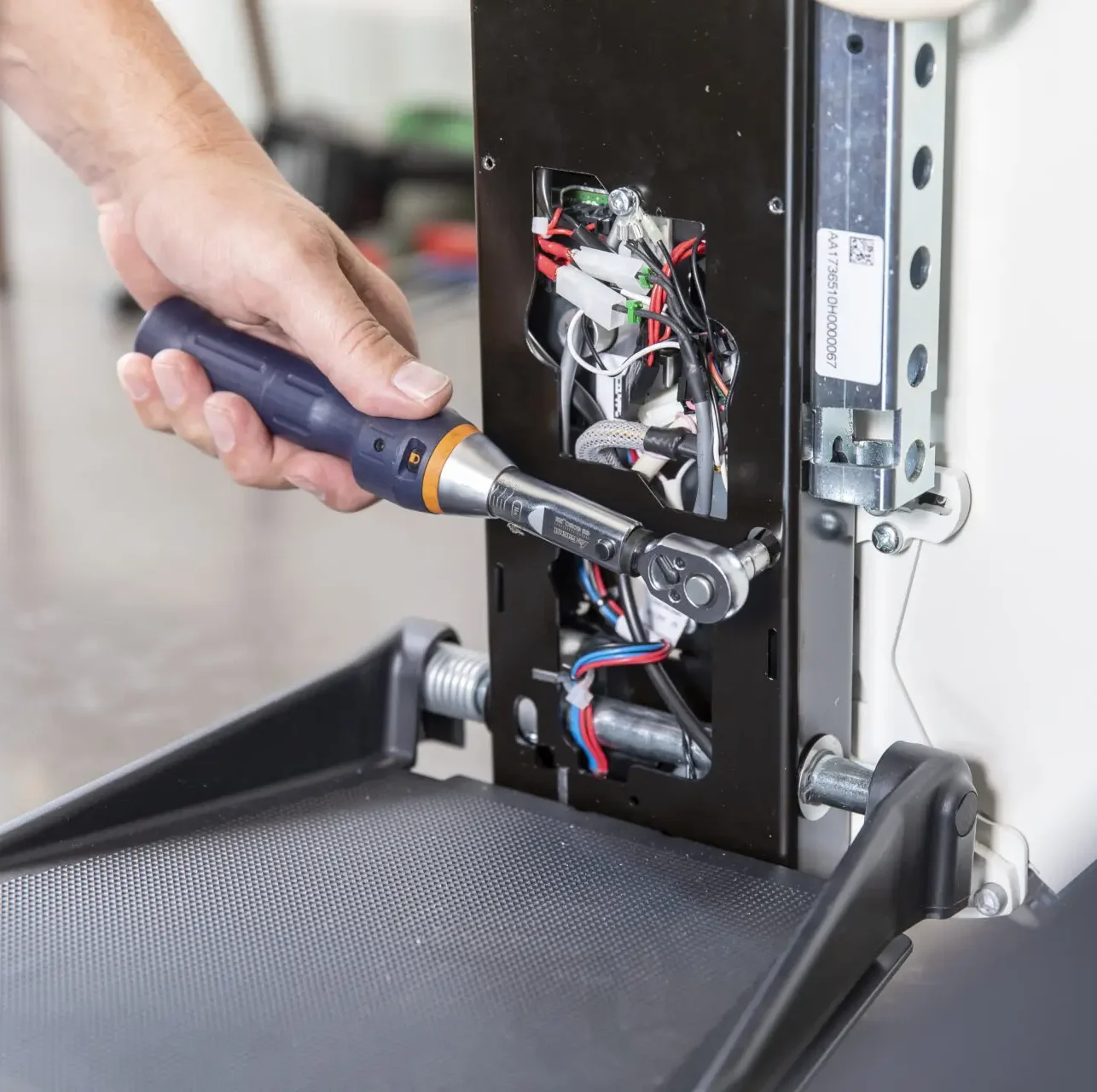 A man uses a socket set to fit a plate onto a newly-repaired stairlift.