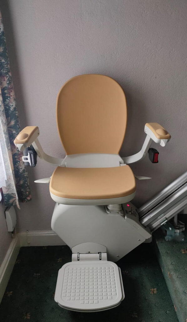 A closeup of a Reconditioned Acorn Stairlift in a home.