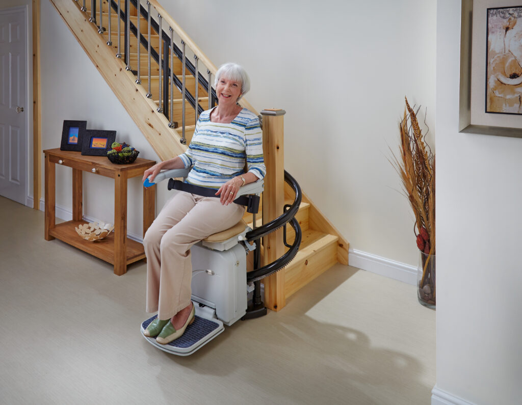 Woman sits comfortably on her Curved Stairlift.