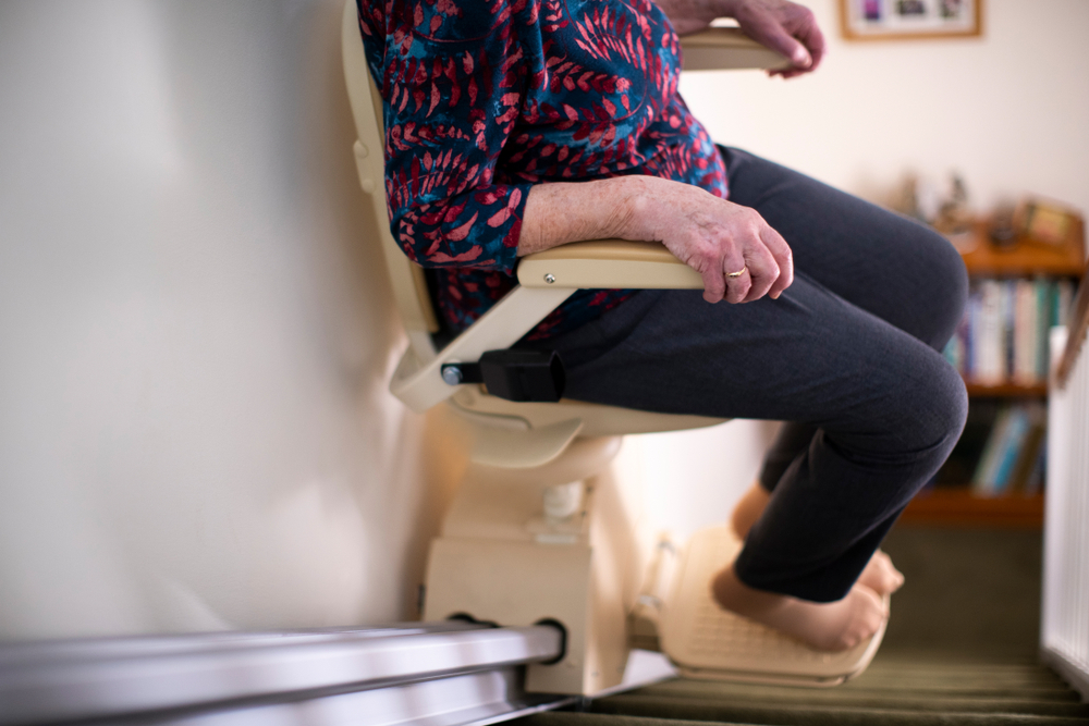 Senior,Woman,Sitting,On,Stairlift ,At,Home