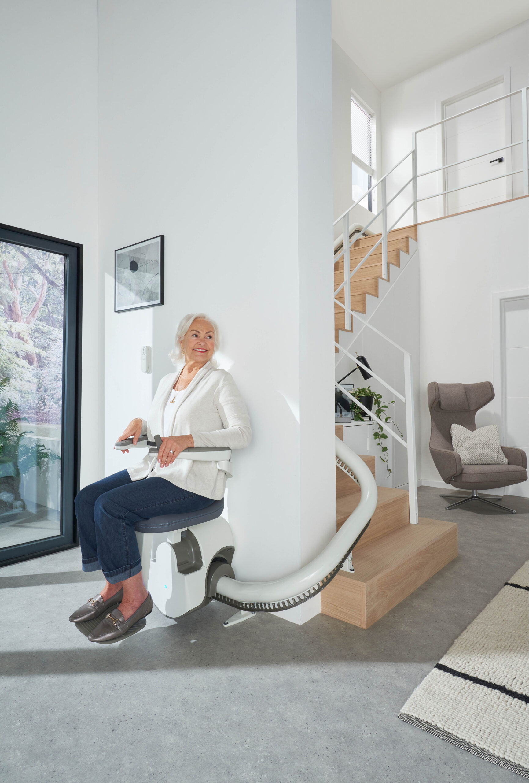 an elderly woman sitting on a Flow X stairlift