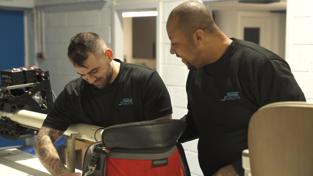 Stairlift Engineers working hard to repair a stairlift rail.