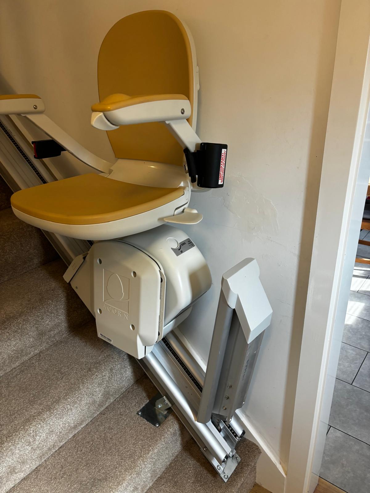 An Acorn 130 Stairlift with a hinged rail to allow for more clearance at the bottom of the stars.