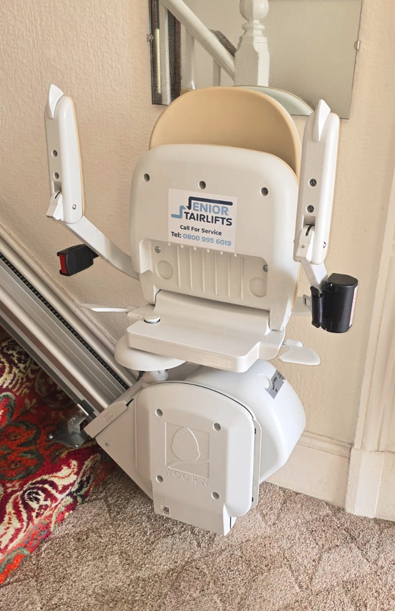 An Acorn 130 T700 stairlift installed with a senior stairlifts contact sticker