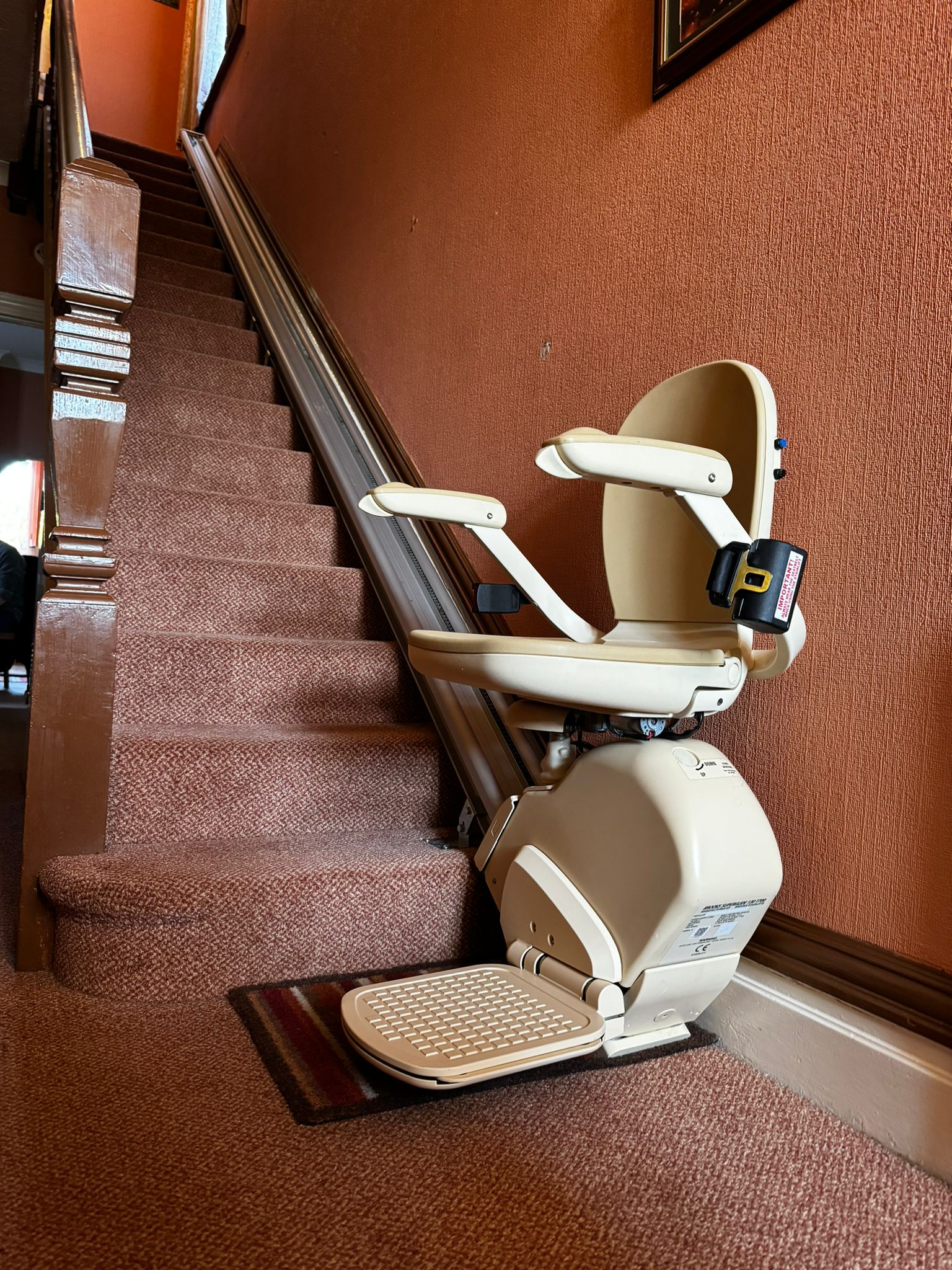 A Brooks 130 Stairlift installed in a terracotta brown styled household