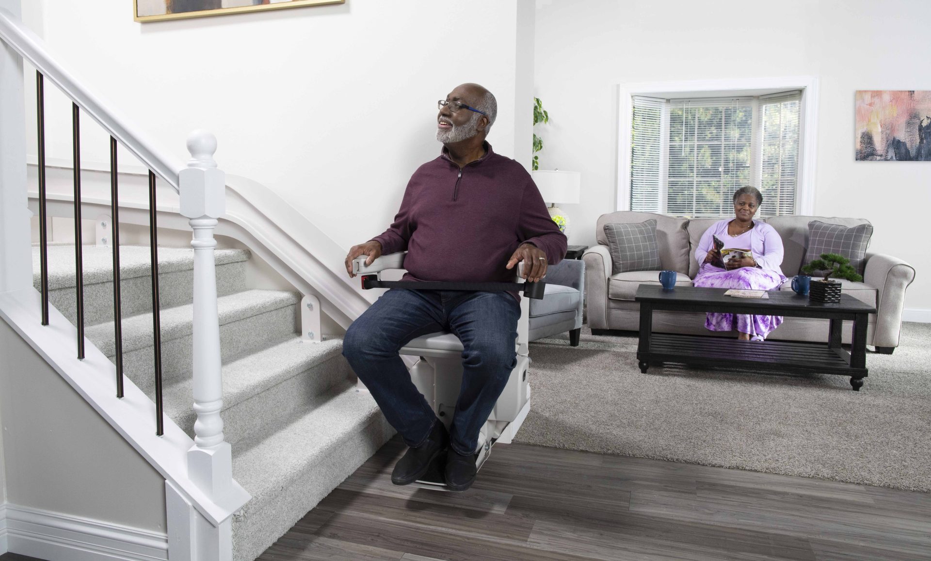 A man sitting on his bruno elite curved stair lift.
