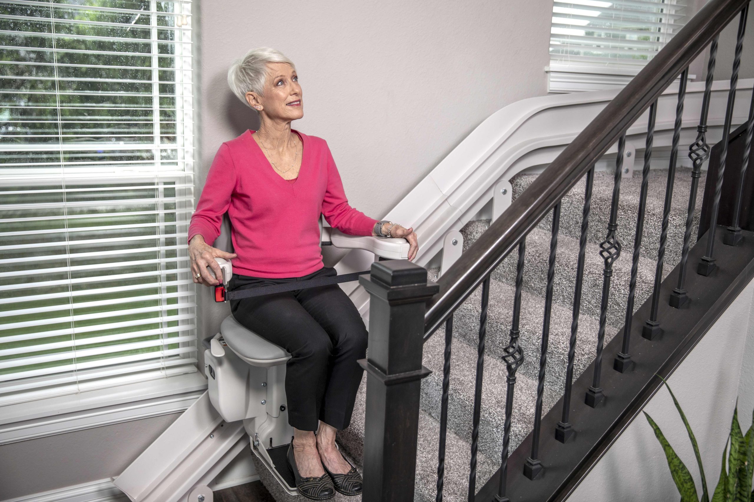 A woman enjoying her Bruno Elite Curved stair lift.