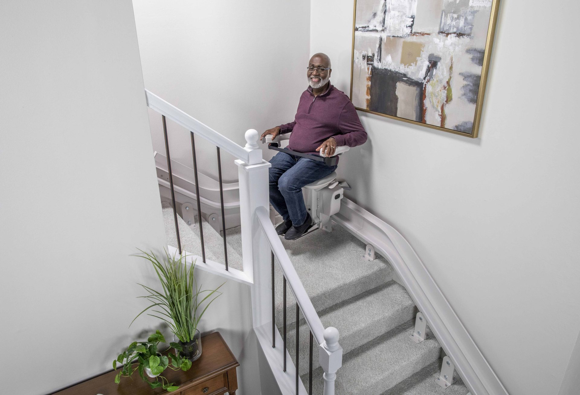 A man riding a bruno elite curved stairlift.